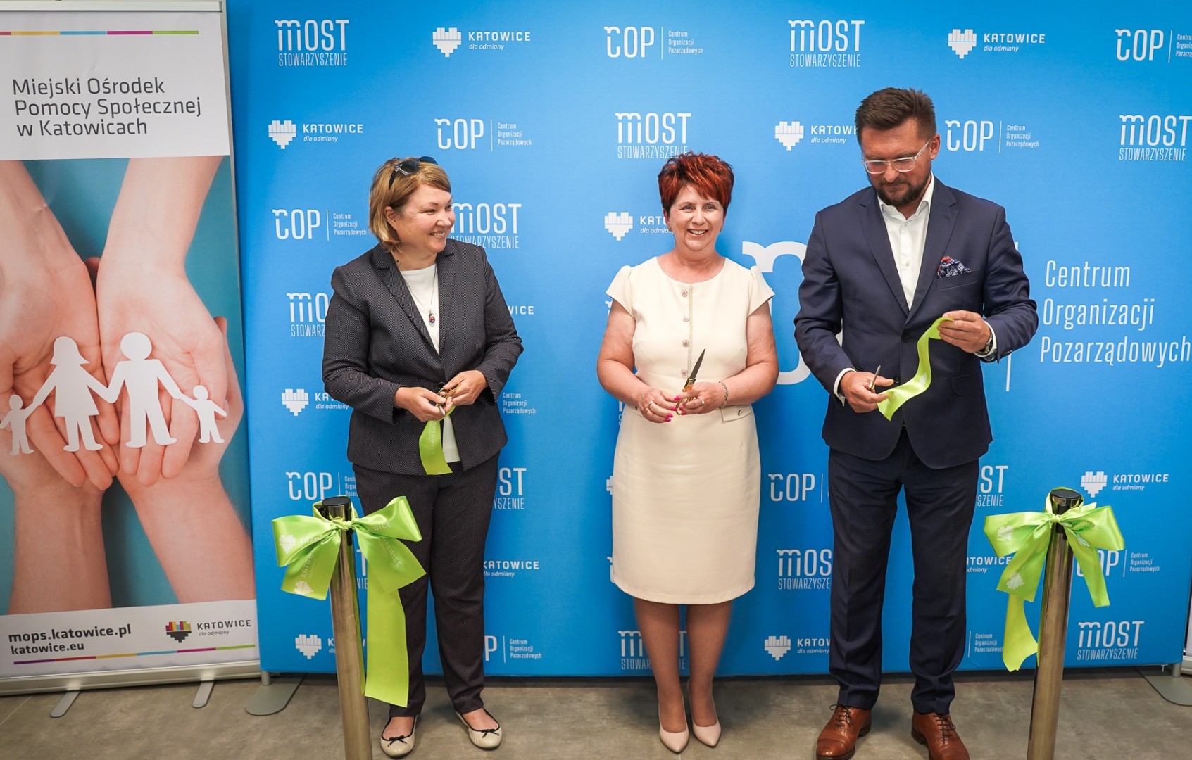 Zdjęcie prezentuje Prezydenta Miasta Katowice, dyrektora MOPS Katowice oraz prezes zarządu Stowarzyszenia „Most” przecinających wstęgę symbolizującą uroczyste otwarcie budynku na ulicy Wita Stwosza